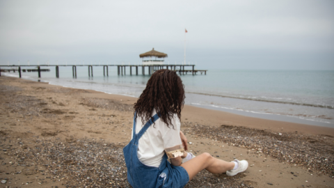 Girl sitting on the beach alone