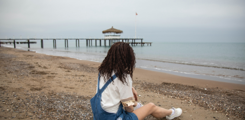 Girl sitting on the beach alone