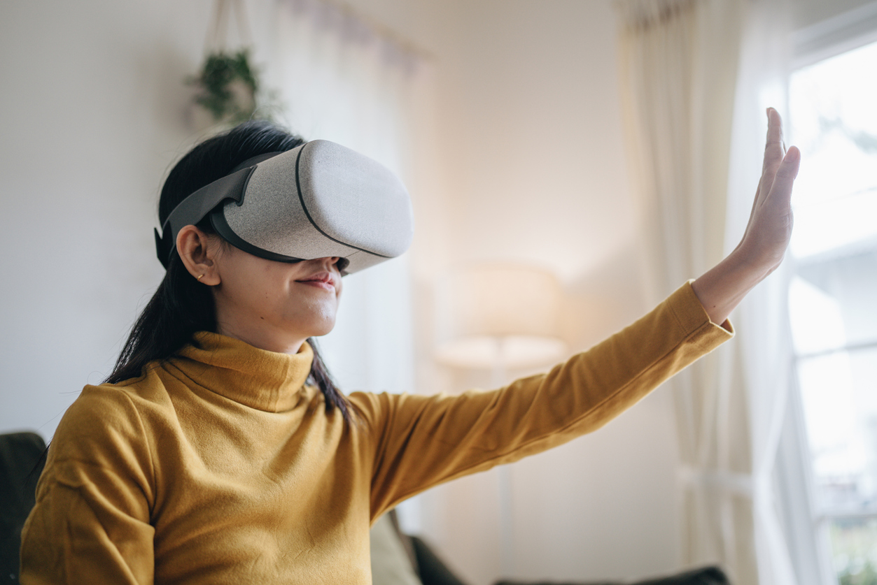 Asian female using VR Glasses at home