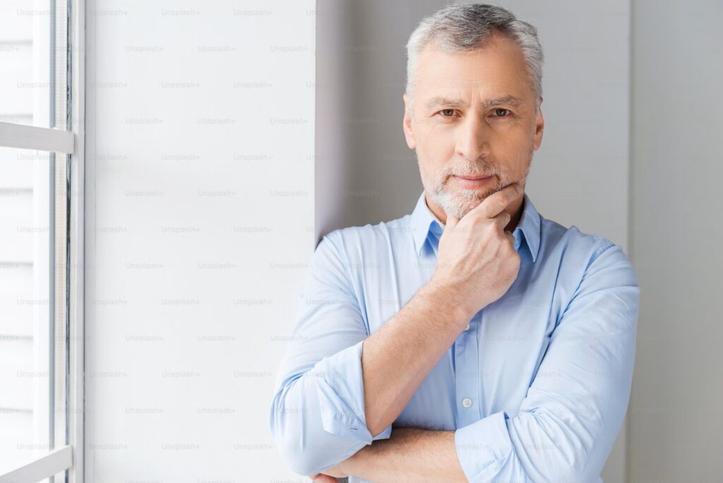 Photo of a man with arms folded and right hand under his chin.