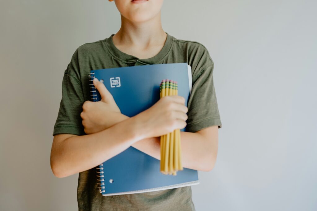 Back to School photo of a boy holding a notebook and pencils