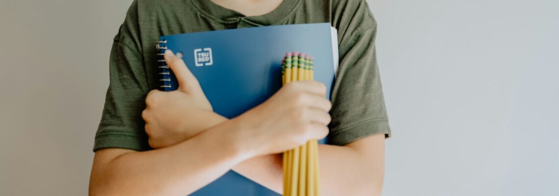 Back to School photo of a boy holding a notebook and pencils
