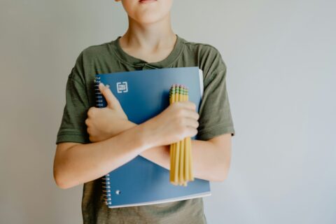 Back to School photo of a boy holding a notebook and pencils