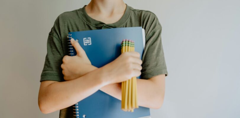 Back to School photo of a boy holding a notebook and pencils