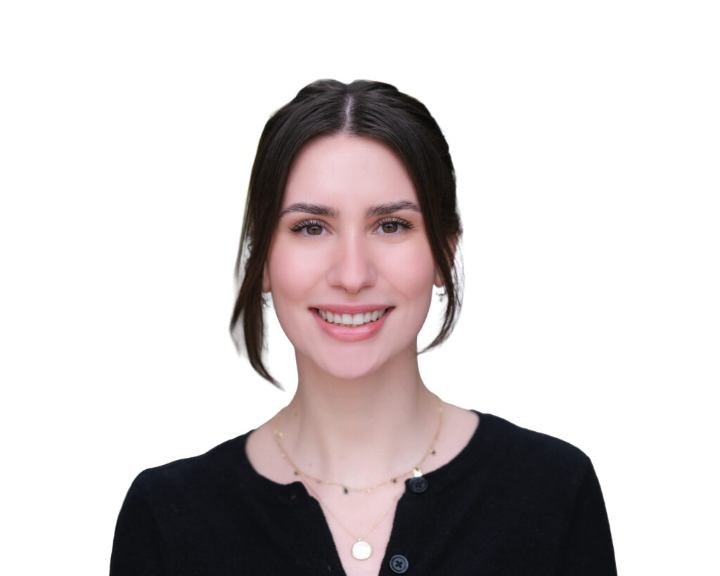 Smiling woman with dark hair wearing a black sweater and layered gold necklaces, against a white background (partial headshot).
