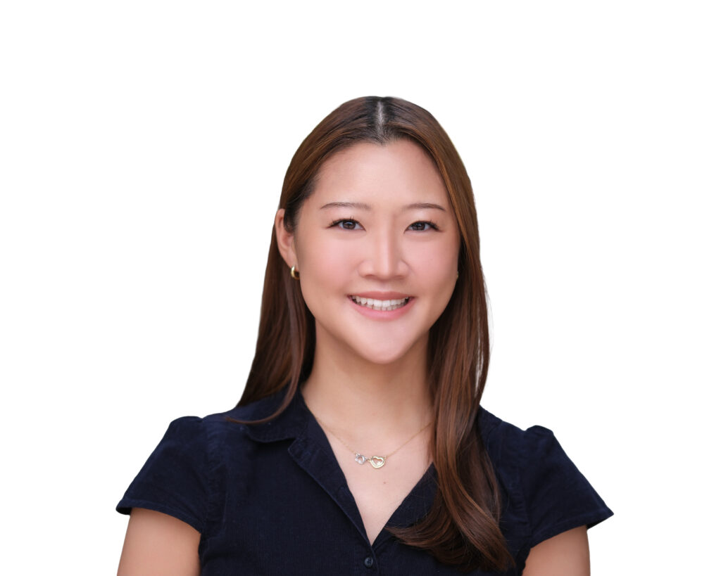 Smiling woman with long brown hair wearing a navy shirt against a white background (portrait)